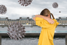 A woman is covering her face from a coronavirus floating in the air