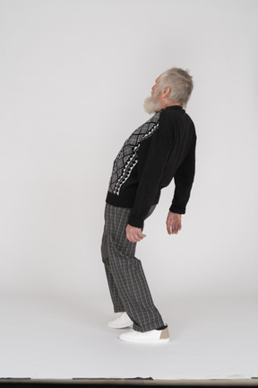 Elderly man standing and bending back