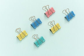 Colourful paper clips on blue background