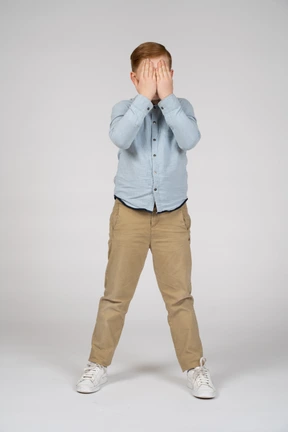 Front view of a boy covering face with hands