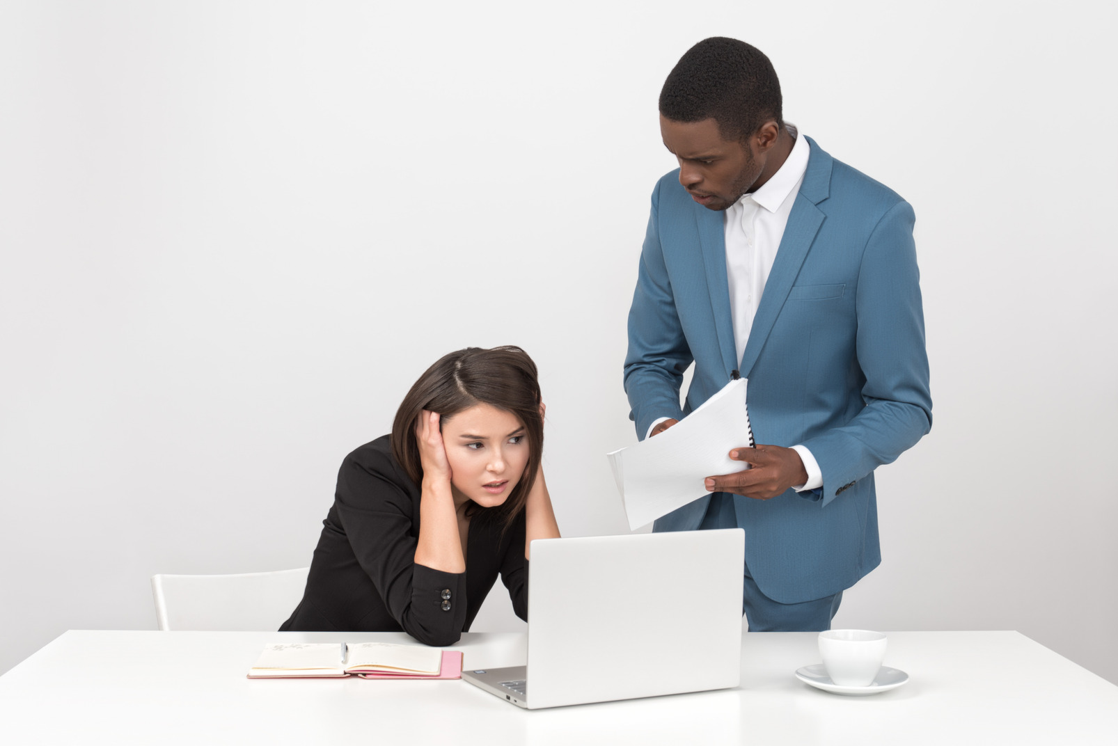 Man showing some papers to stressed female colleague