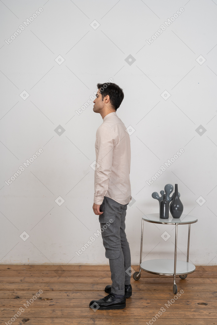 Homem com roupas casuais em pé de perfil