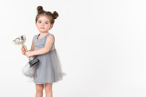 Niña sosteniendo una copa de premio