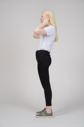 Side view of a young woman covering her ears