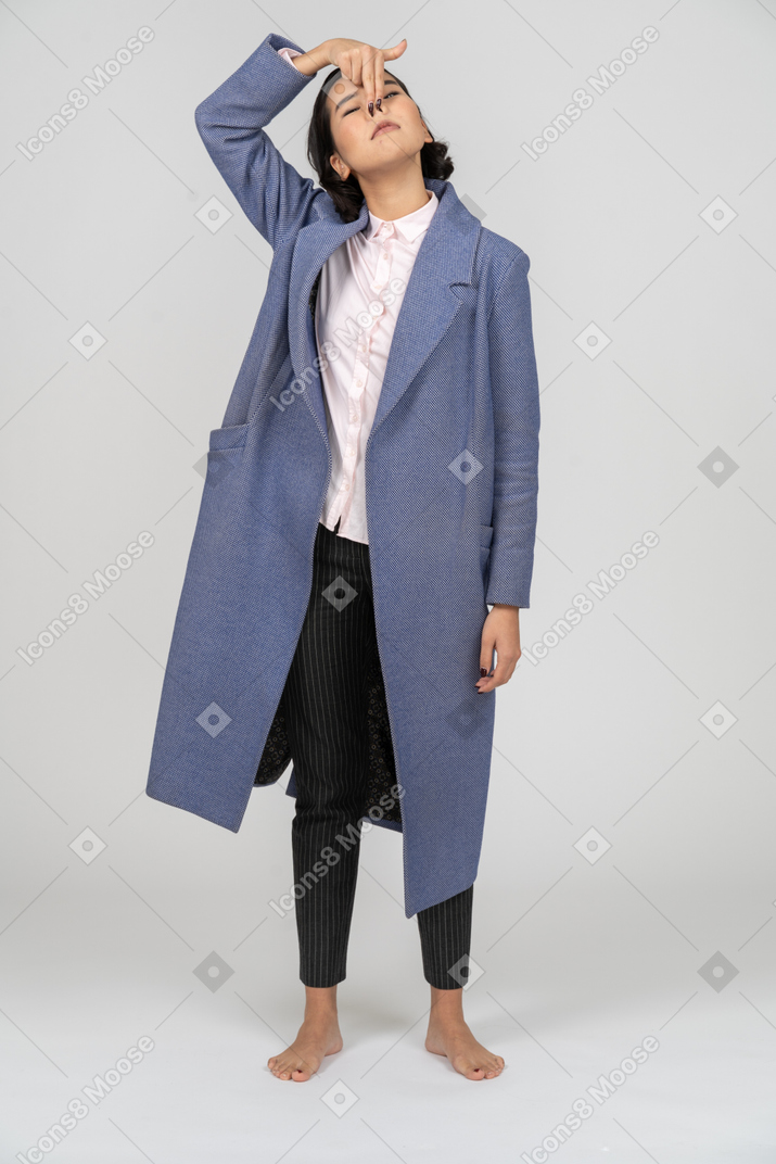 주둥이를 만드는 파란색 코트를 입은 여성의 전면 모습