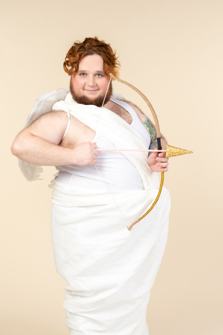 Big guy dressed as a cupid holding bow and arrow