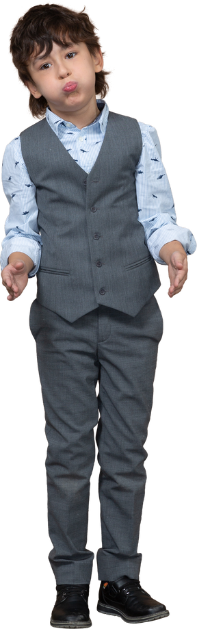 Front view of a boy in grey suit making faces