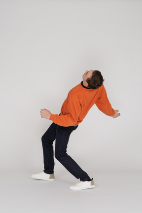 Young man in orange sweatshirt jumping