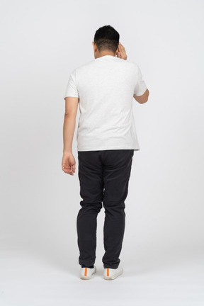 Rear view of a man in casual clothes eavsdropping