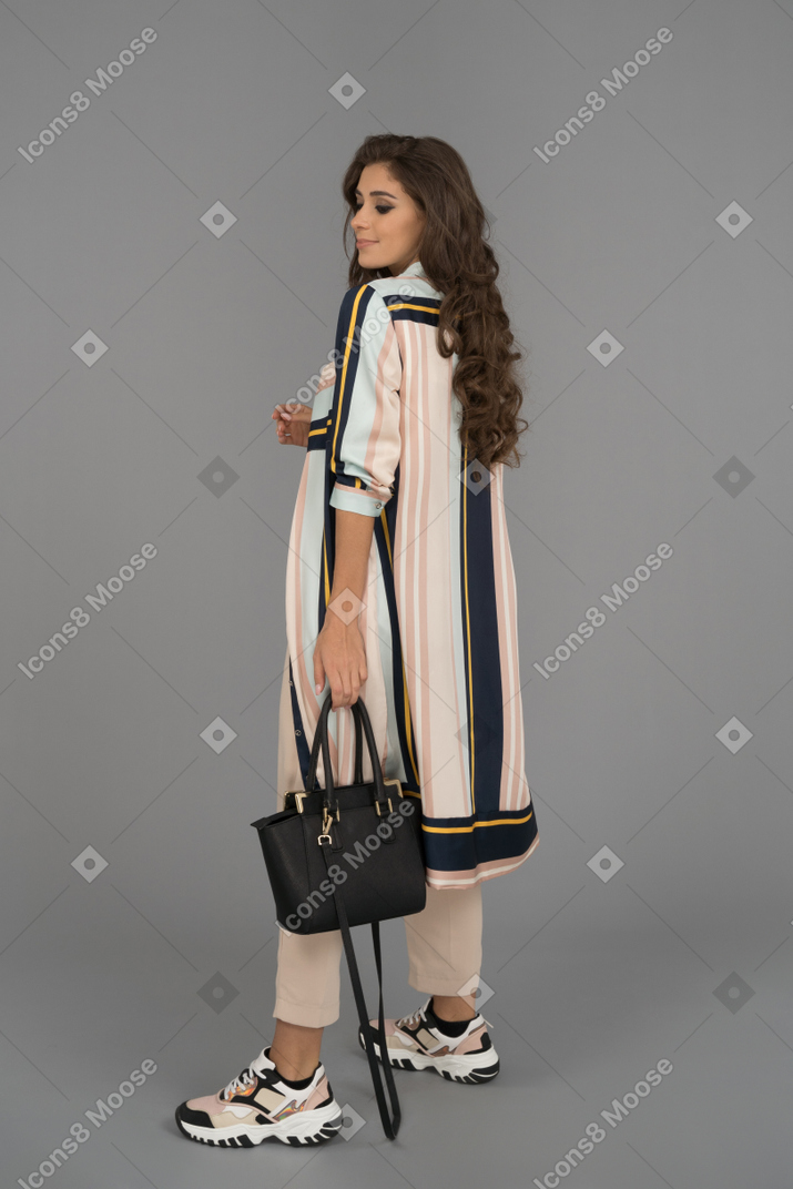 Beautiful young woman posing with handbag