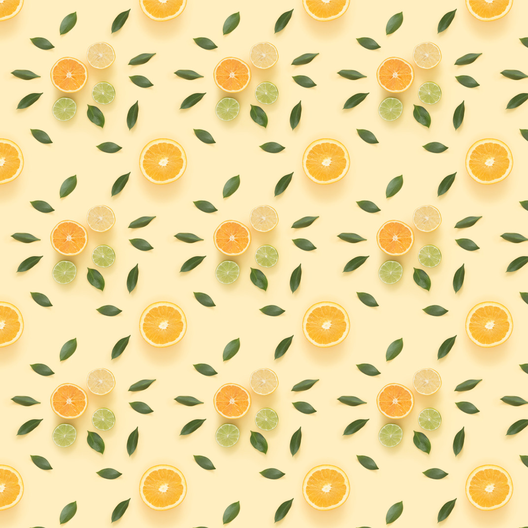 Citrus slices and green leaves over pastel background