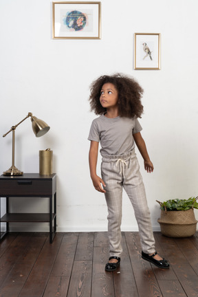 Good looking girl kid posing on the apartment background