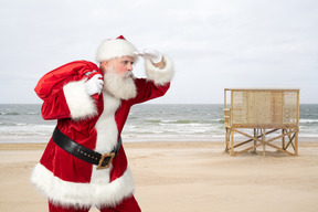 Der weihnachtsmann geht am strand spazieren