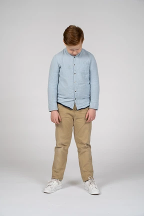Front view of a boy in casual clothes bending head down