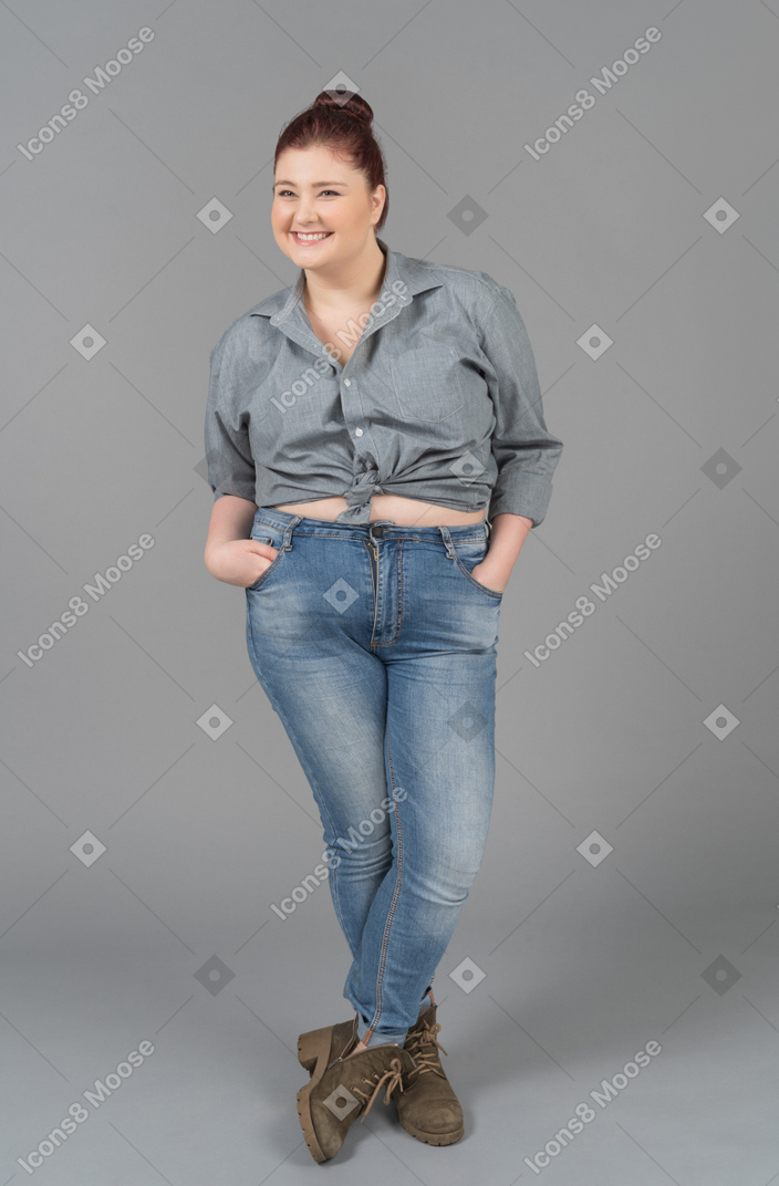 Smiling young woman standing with her lags crossed