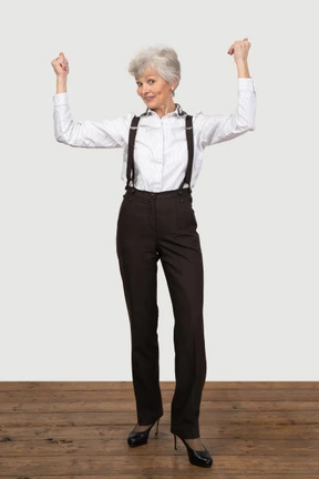 Mujer vestida formalmente celebrando con las manos en alto