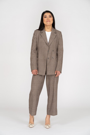 Front view of a smirking young lady in brown business suit