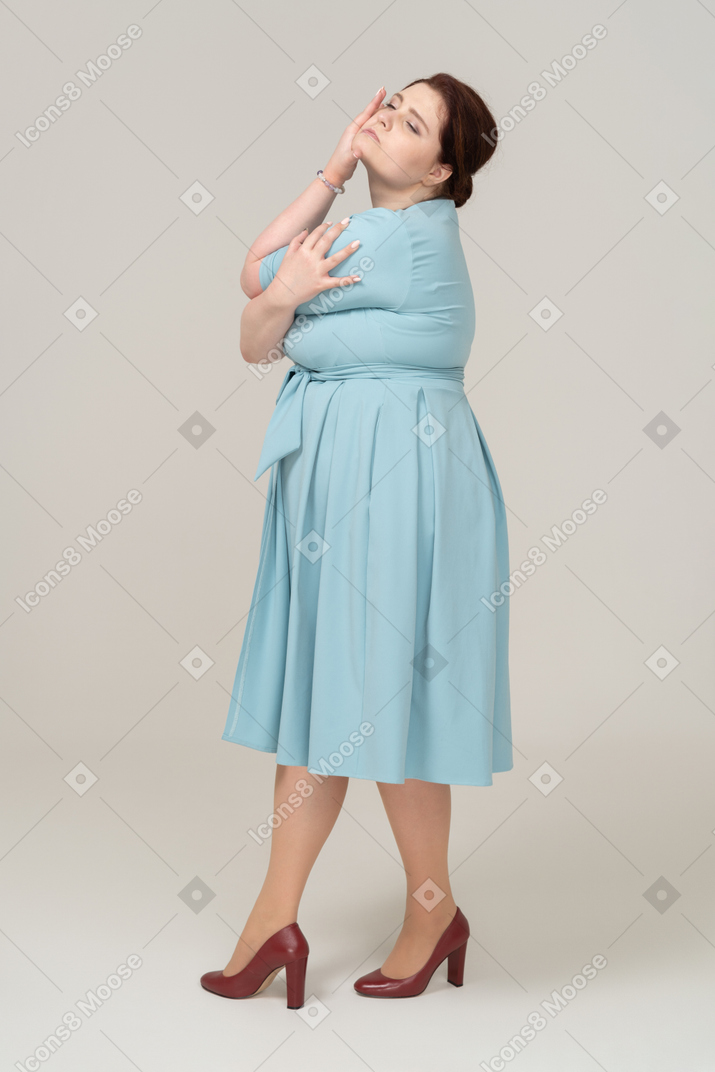 파란 드레스 포즈를 취하는 여자의 측면보기