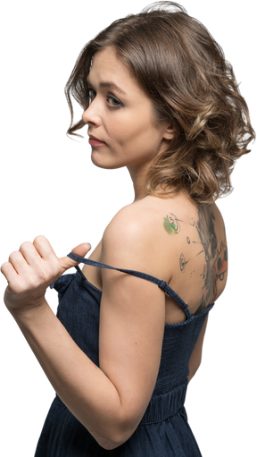Donna con la schiena tatuata che si spoglia