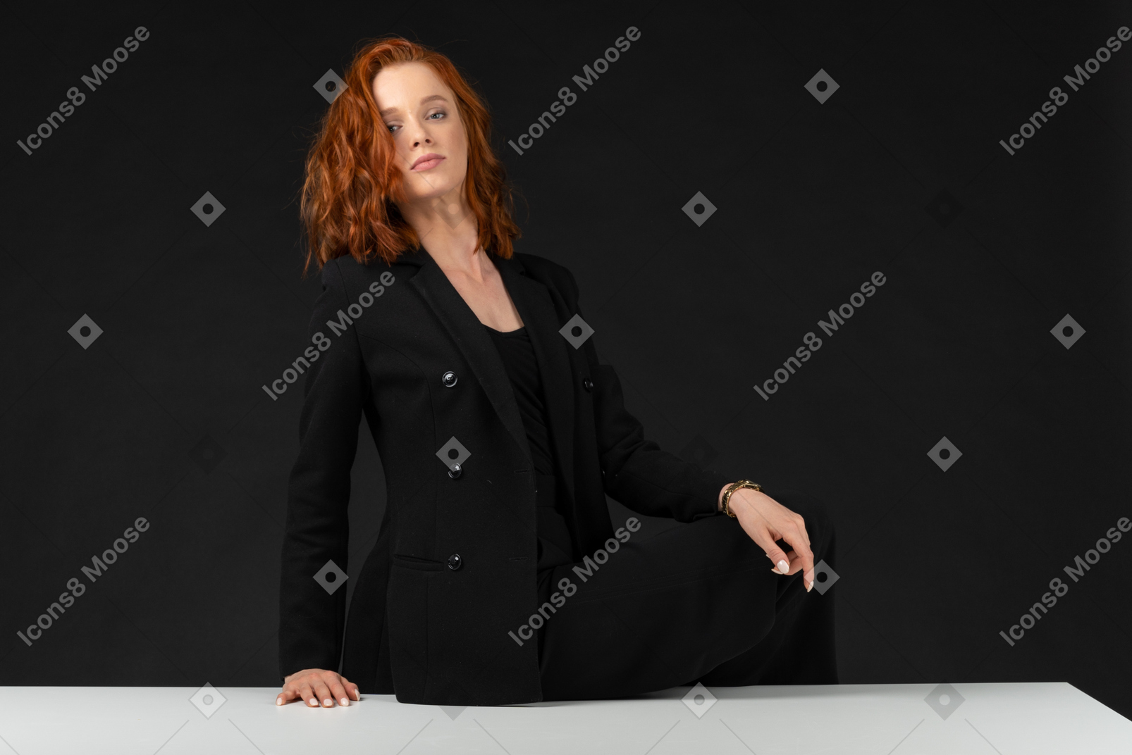 Beautiful red haired woman sitting on the white table