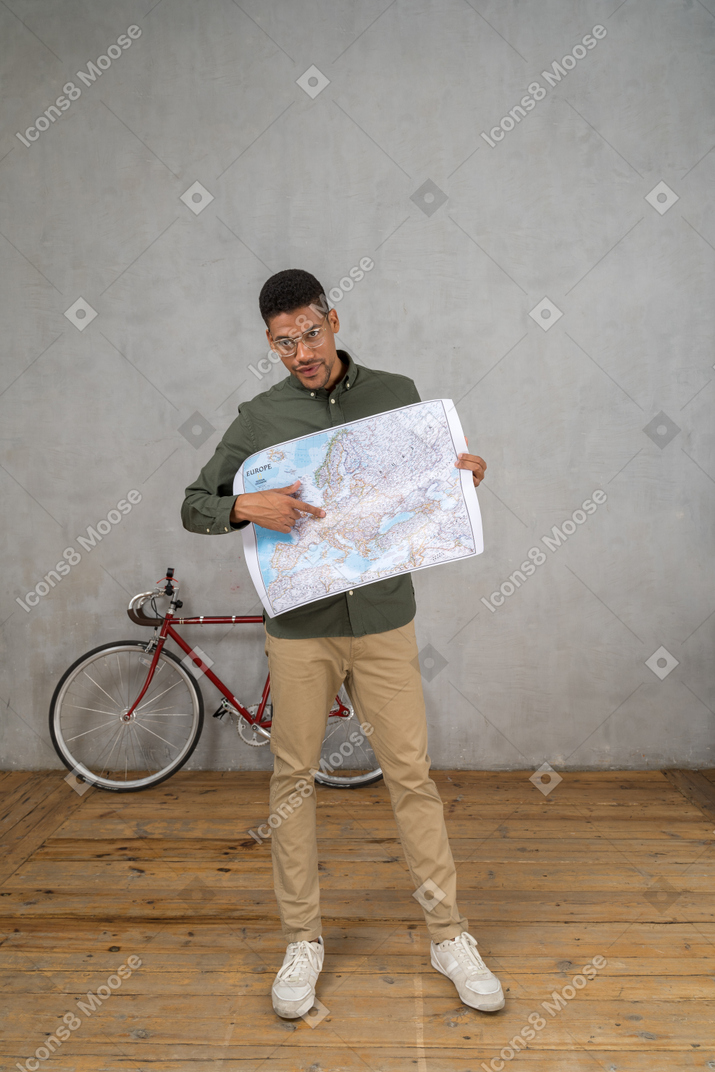 Вид спереди человека, держащего и указывающего на карту