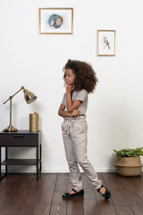 Good looking girl kid posing on the apartment background