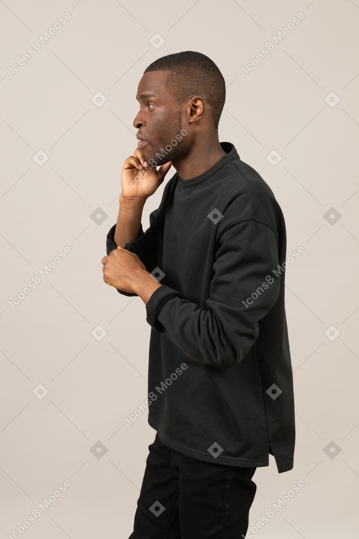 Seitenansicht eines mannes in schwarzer kleidung, der am telefon spricht