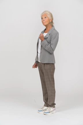 Side view of an old lady in suit showing fist