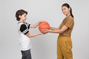 Pe tescher and pupil holding basketball ball