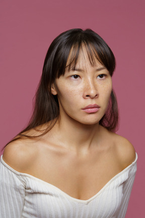 Close-up of a tired unemotional woman looking aside