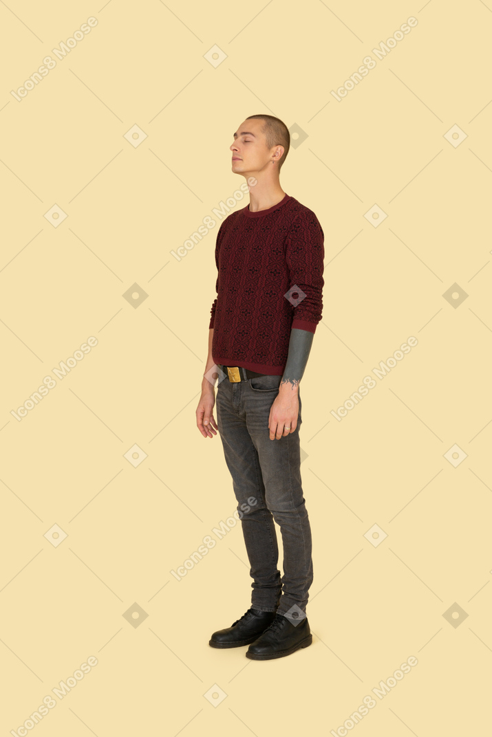 가만히 서있는 빨간 스웨터를 입은 젊은 남자의 3/4보기