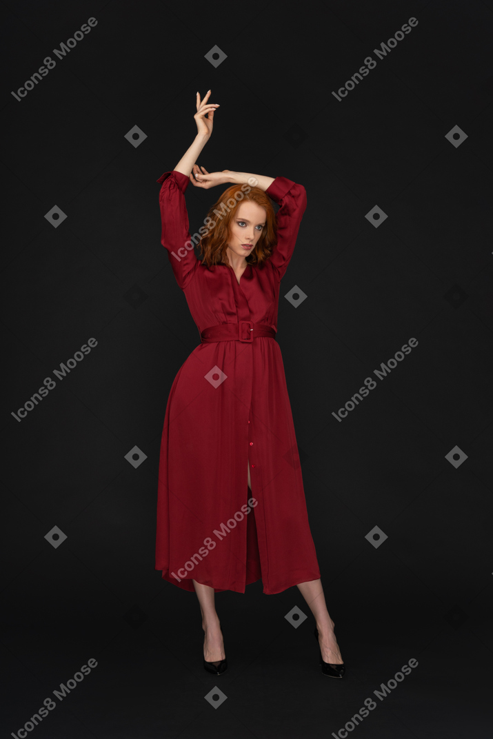 Giovane donna in rosso con le braccia alzate