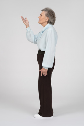 Vista laterale di una donna anziana che gesticola in modo persuasivo