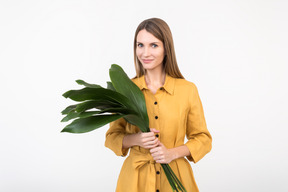 Young woman holding green leaves