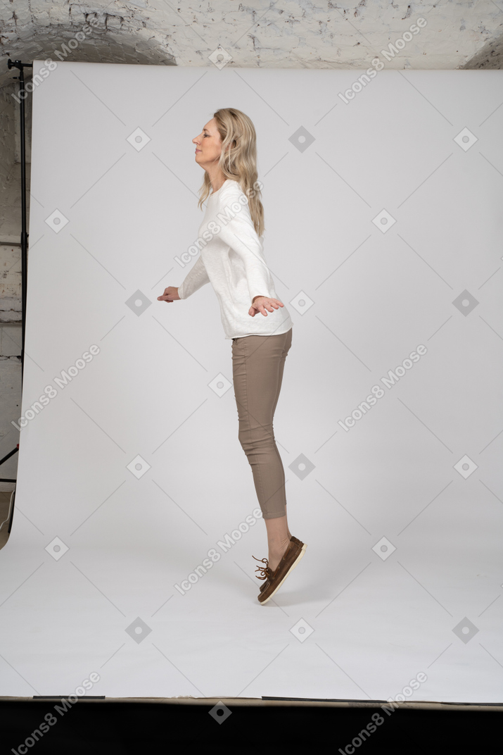 カジュアルな服を着てジャンプする女性