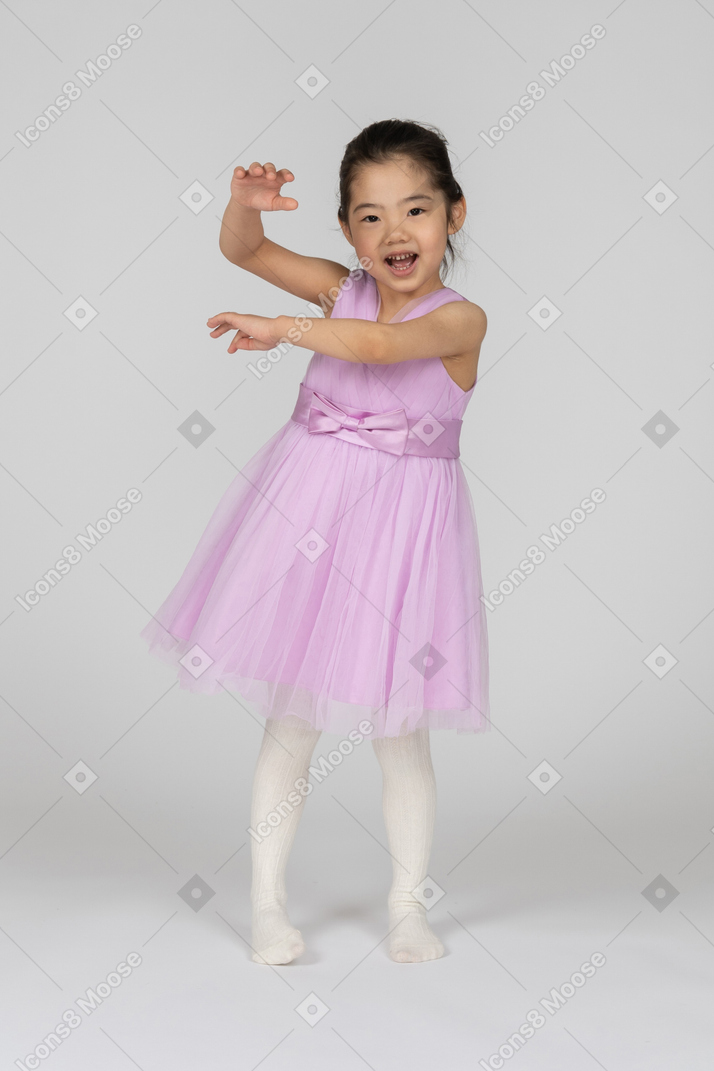 Garota feliz em um vestido rosa gesticulando