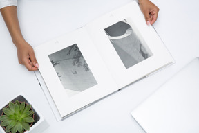 Female hands holding open black and white photo album