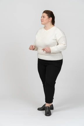 Plus size woman in white sweater posing