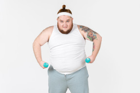 Angry looking big guy in sportswear lifting hand weights