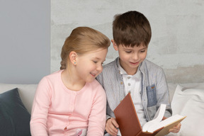 Um casal de crianças lendo um livro