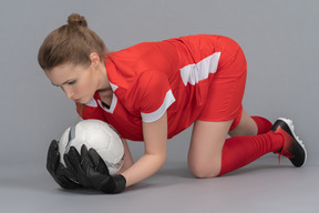 A female goalkeeper standing on all fours