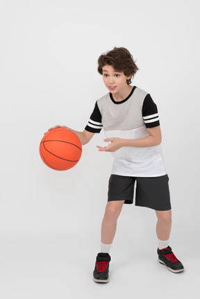 Boy hitting a basketball ball