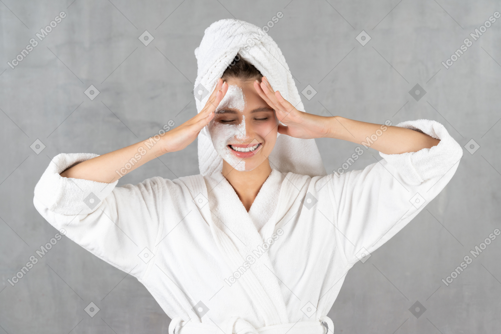 Woman in bathrobe smiling and touching temples