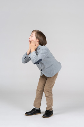 Boy leaning forward and touching his mouth