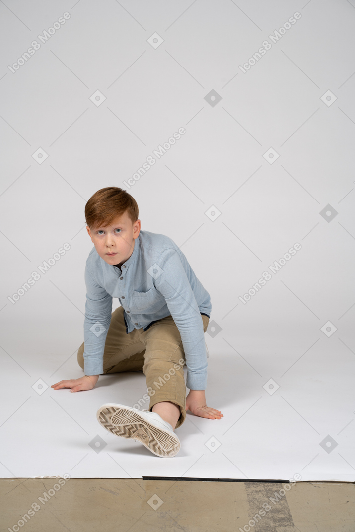 Vista frontal de un niño con camisa azul haciendo una división