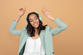 Contented young girl wearing headphones and partying