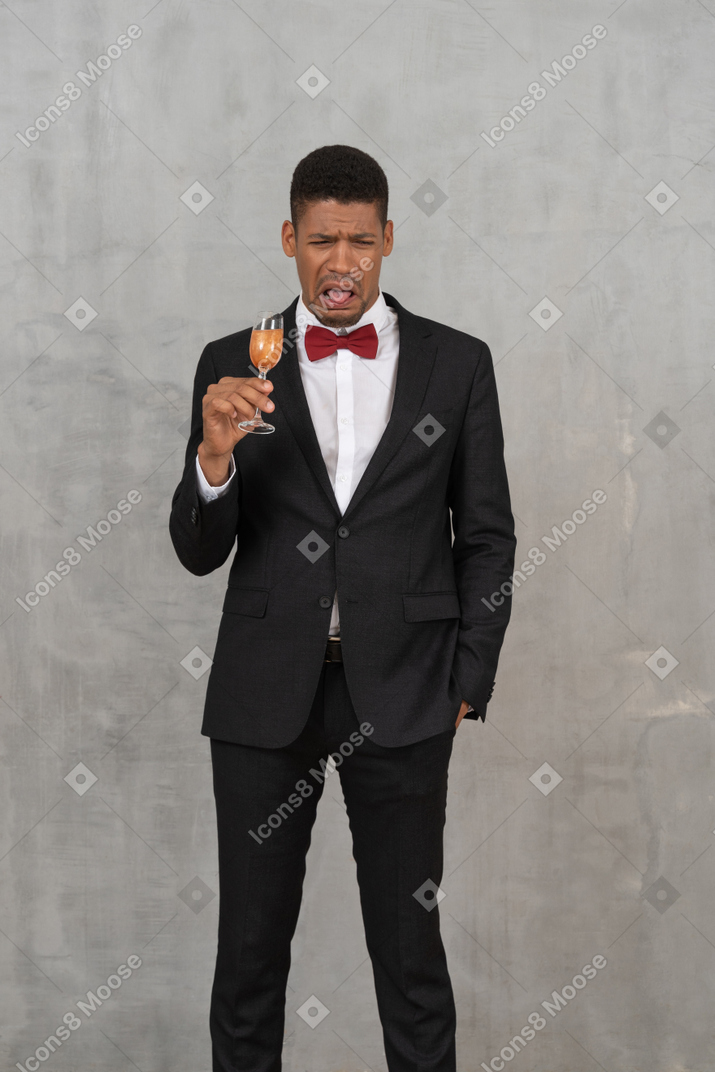 Young man with a glass of champagne experiencing nausea