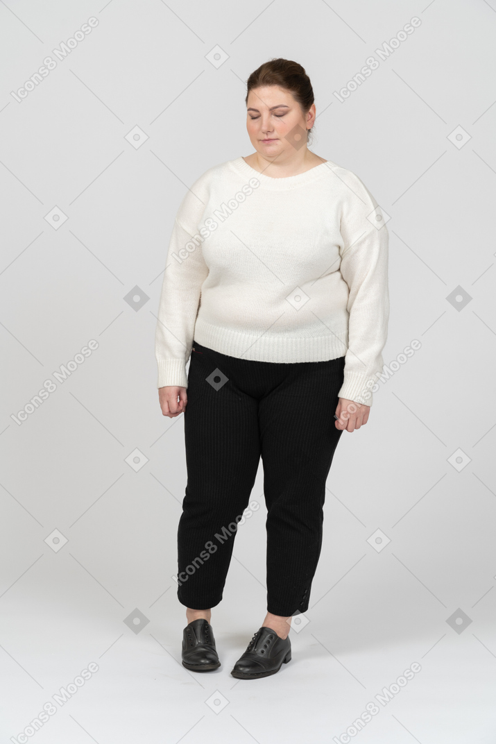 Mujer regordeta en suéter blanco mirando hacia abajo