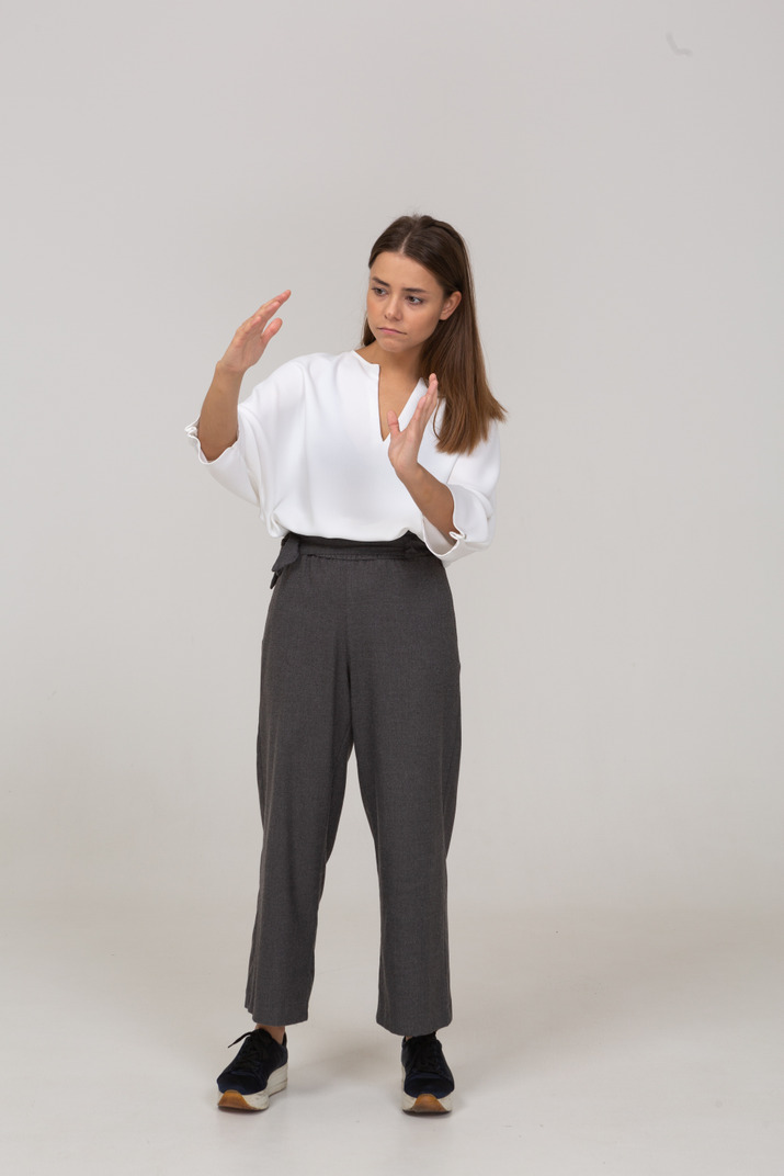 Front view of a young lady in office clothing showing a size of something