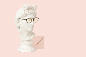 Statue bust in glasses next to an envelope